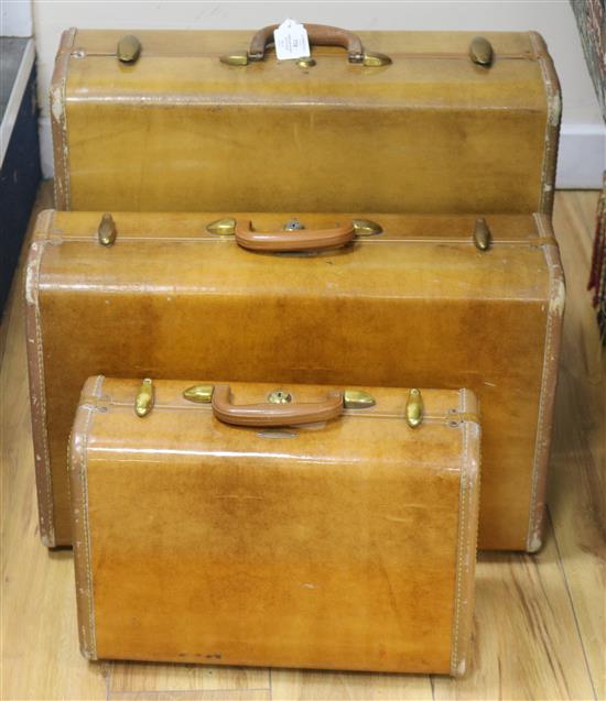 A graduated set of three 1940s-50s tan coloured suitcases